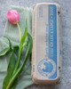 Closed blue Local Hens® Grade A Large Printed Paper-Pulp Carton with UPC on a table next to a pink flower