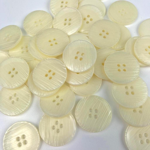 Cream four hole button with no rim edge and slight concave centre.