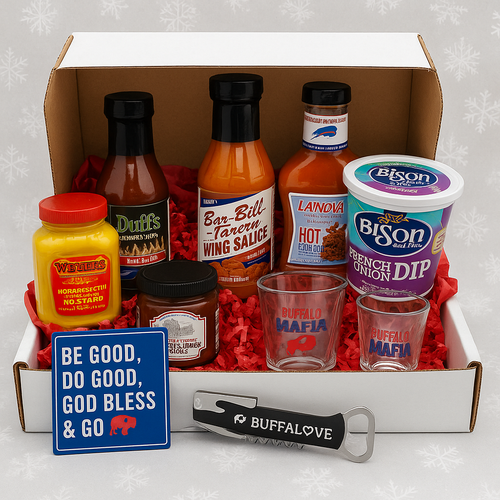 Holiday Buffalo Tailgate Kit — white gift box filled with Buffalo favorites including Duff’s and Bar-Bill wing sauces, La Nova sauce, Rootie’s Blue Cheese, Bison French Onion Dip, Weber’s Mustard, Buffalo Mafia shot glasses, BuffaLove opener, and blue magnet reading “Be Good, Do Good, God Bless & Go Bills.” Displayed with red crinkle paper and snowflake background for a festive holiday look.
