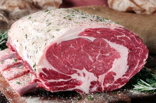 Bone-in prime rib roast prepared for roasting, a large marbled beef rib roast ready for cooking.