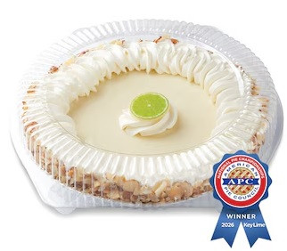 Award-winning Publix Original Key Lime Pie with whipped topping and lime garnish displayed in bakery packaging with American Pie Council 2026 award ribbon.