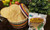 Stack of El Milagro corn tortillas in a woven basket next to a bag of El Milagro tortillas on a kitchen counter with limes and peppers in background.