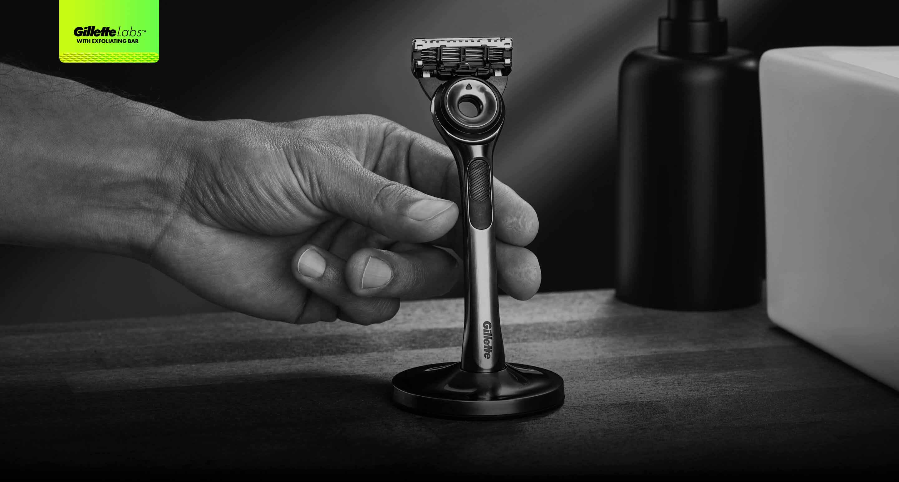 Grayscale image of a man's hand reaching for an upright razor.
