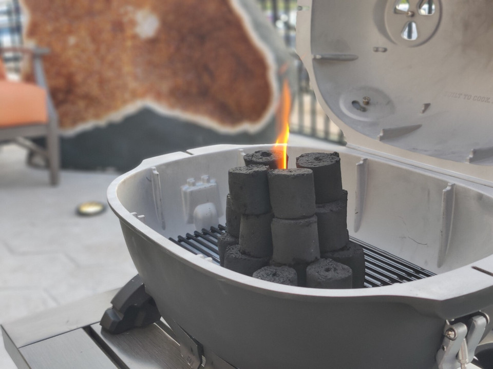 Coconut shell charcoal arranged in a kettle grill ready for lighting