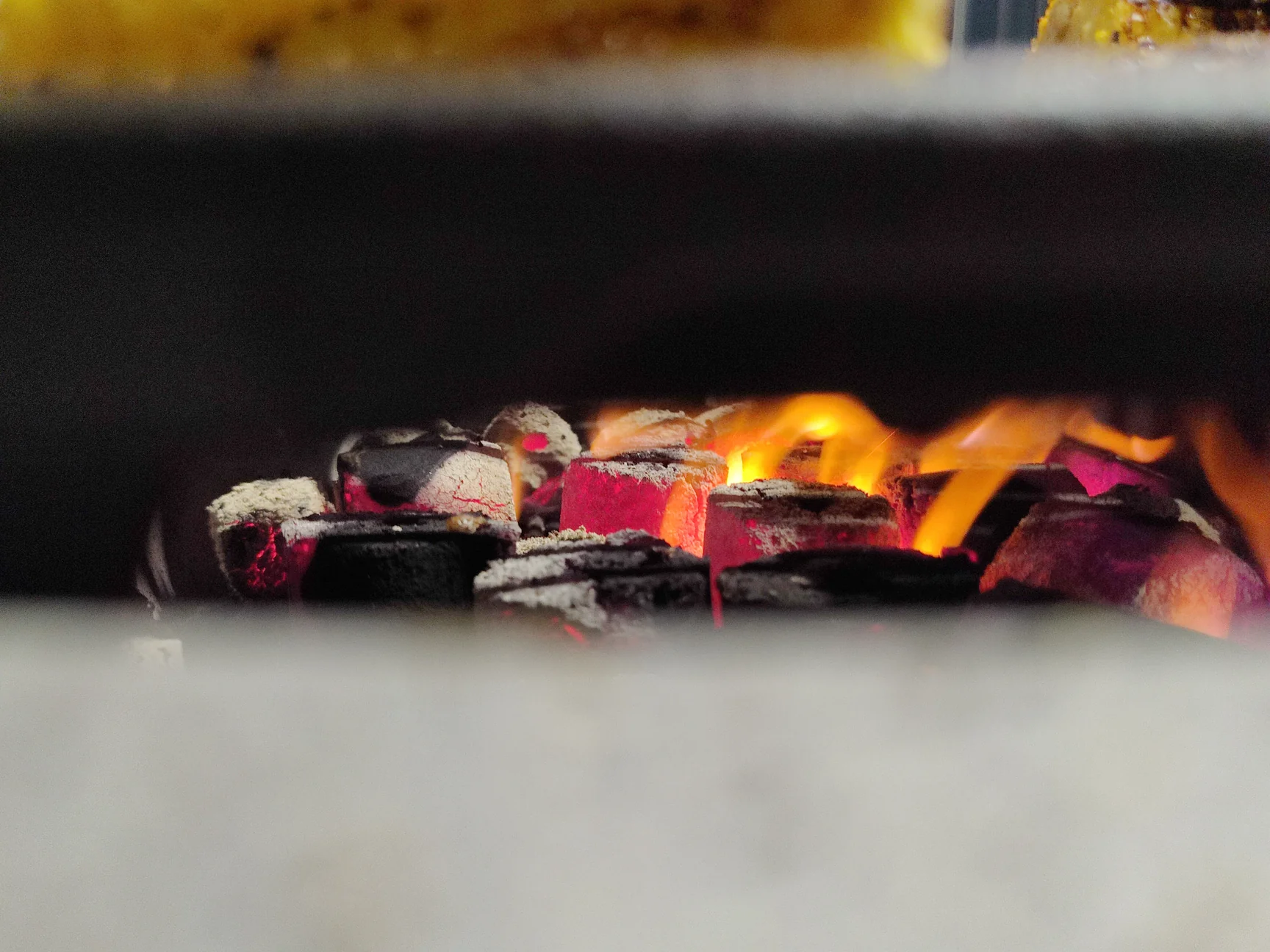 Vegetables grilling over glowing Coco-BBQ coconut shell charcoal