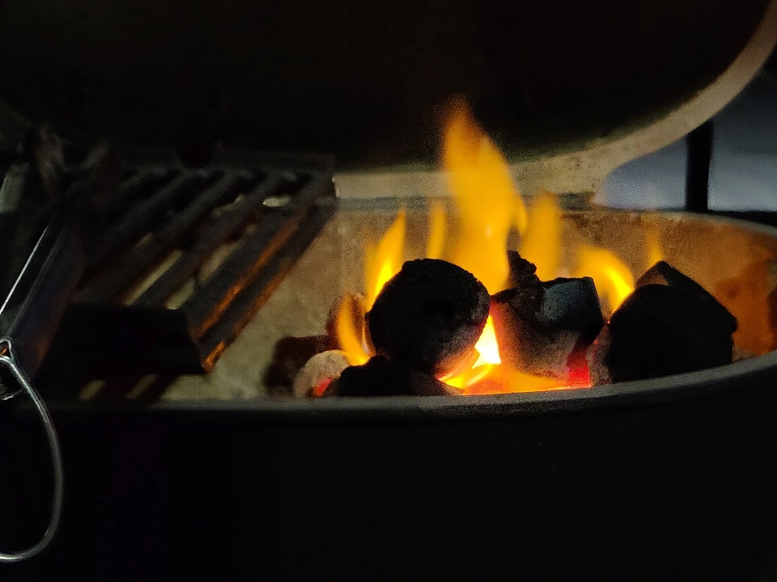 Coconut shell charcoal burning in an open barbecue grill