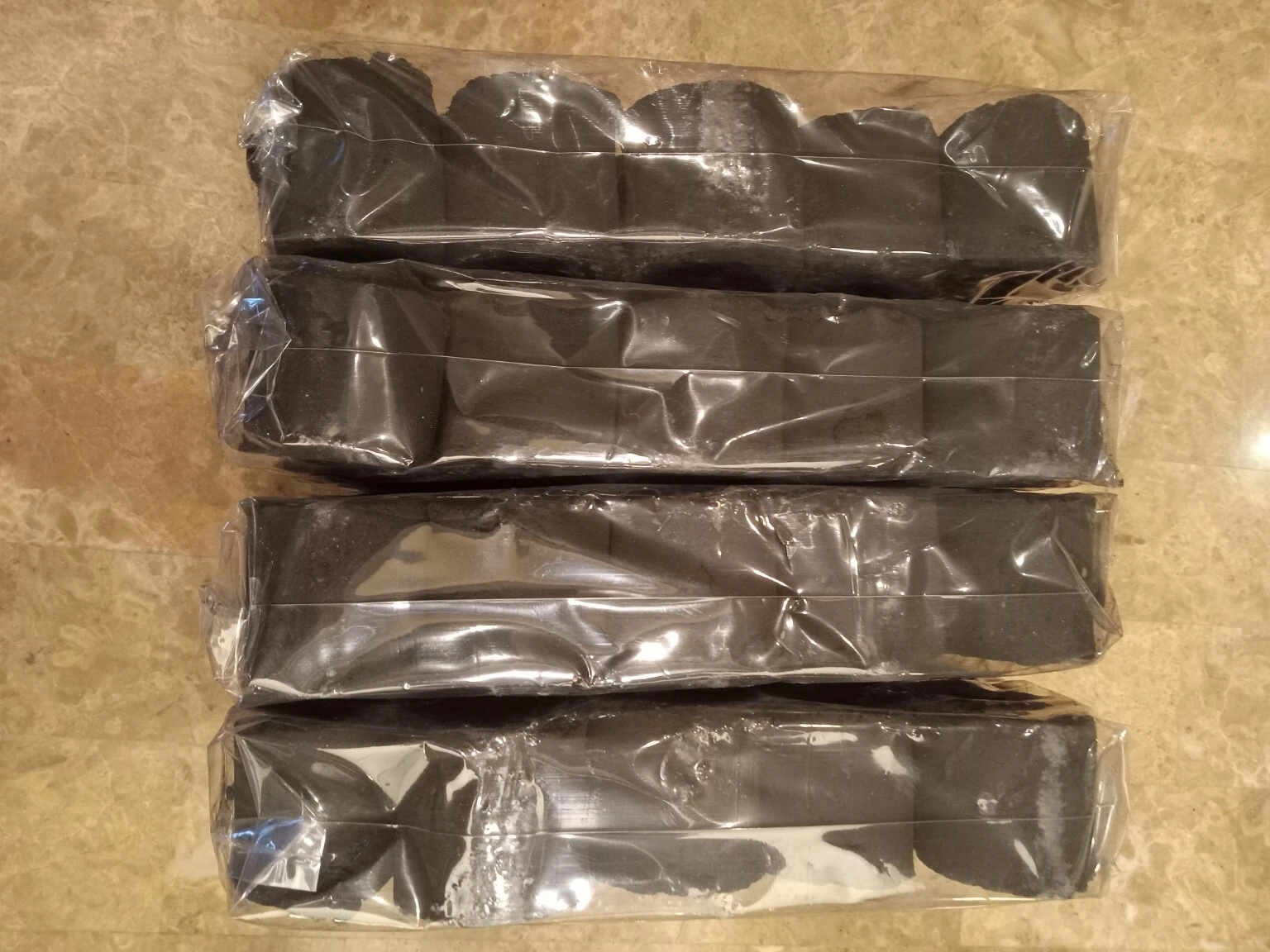 Four wrapped portions of COCO-BBQ coconut shell charcoal