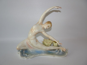 20th Century Art Deco German porcelain figure of a woman doing a dance pose next to two flowers.