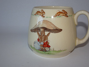Royal Doulton Bunnykins mug "Cuddling under the mushroom" signed by Barbara Vernon circa 1930s.