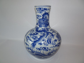Vintage Chinese blue and white vase decorated with dragons chasing flaming pearls amidst clouds above crashing sea waves, mark to base.