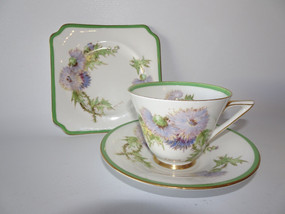 Royal Doulton Glamis Thistle trio signed by P. Curnock with thistle design – teacup, saucer, and square plate