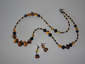 Francesca – handcrafted Murano glass necklace and earrings set in amber, gold, and black tones.