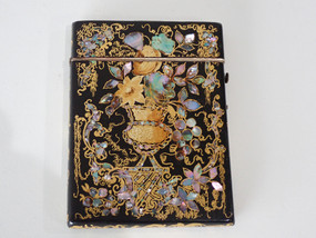 Victorian black lacquered card case decorated with gold gilt scrollwork and iridescent mother-of-pearl and abalone shell floral motifs.