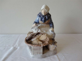 Bing & Grøndahl Fisherman's Wife Danish porcelain figurine in traditional dress seated beside baskets, circa 1950s, 20cm tall.