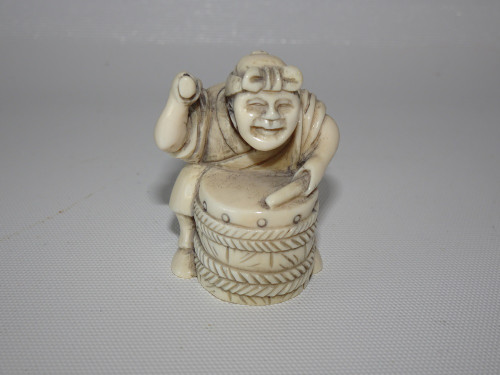 Japanese ivory netsuke "Drummer", detailed in design of a man beating a drum.