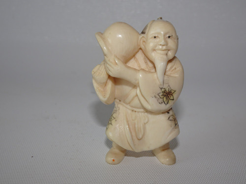 Antique Japanese ivory netsuke detailed in design of a man holding an item dated Meiji period (1868-1912),  signed