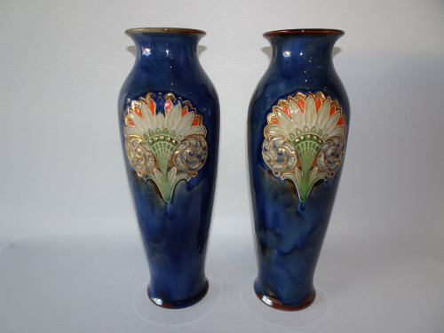 A beautiful pair of Royal Doulton Lambethware vases in mottled blue glaze and classical style acroteria to front