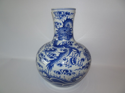 Vintage Chinese blue and white vase decorated with dragons chasing flaming pearls amidst clouds above crashing sea waves, mark to base.