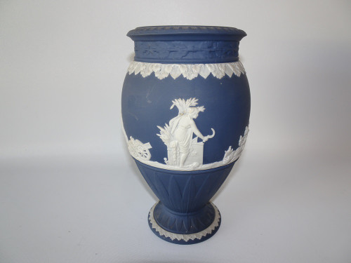 Vintage Wedgwood Portland Blue Jasperware urn-shaped vase with white classical figures, decorative leaf borders and pedestal foot.