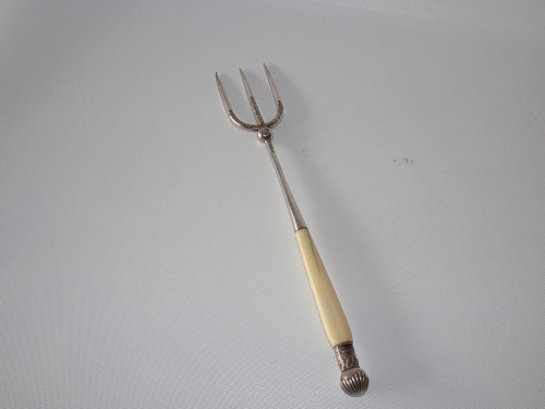 Victorian Sheffield sterling silver three-pronged bread fork with long cream-coloured handle and decorative shell finial.