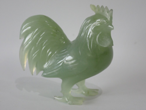 Chinese carved green hardstone rooster with finely detailed plumage and softly translucent finish, circa 1950–1970.