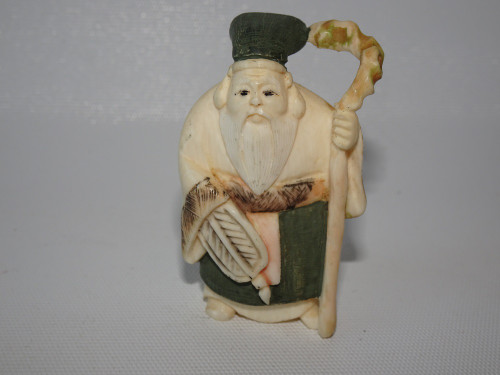 Antique Japanese signed ivory netsuke depicting Jurojin holding a fan and staff, 5 cm high.