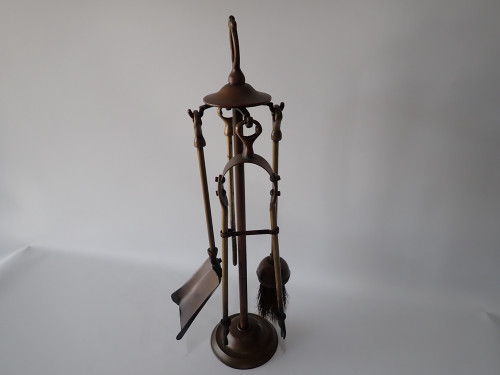 Victorian brass fireplace companion set with poker, tongs, shovel and brush on decorative stand circa 1880–1910.
