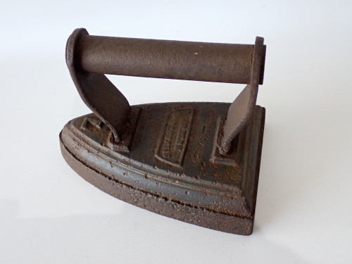 Antique George Salter & Co Sylvester Patent cast-iron sad iron with fixed metal handle, surface rust and age-related pitting.