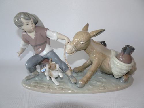 Vintage retired Lladro boy pulling donkey with a dog at his feet.