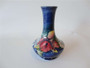 Vintage Moorcroft Orchid pottery vase dated 1947 with pink, coral and cream flowers, green foliage, deep blue glaze and slender flared neck.