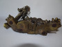 20th century bronze dragon, intricately detailed in dramatic motion clutching flaming pearl on wooden stand