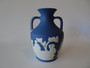 Vintage Wedgwood dark blue jasperware portland vase decorated with classical roman scenes and in original box.