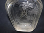 Antique glass liquor bottle/flask deeply engraved with stag and deer in a forest and monogram AH to rear.