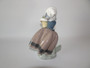 Vintage retired Lladro figure Spring is Here, depicting a young girl holding a pot plant of spring flowers.