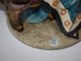 Vintage Italian Pucci porcelain The Stamp Collector figurine depicting a seated gentleman examining stamps beside a lamp and ornate table.