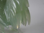Chinese carved green hardstone rooster with finely detailed plumage and softly translucent finish, circa 1950–1970.