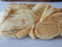 Antique Japanese Meiji period ivory okimono depicting a man and young boy beside a woven basket, signed and displayed on a carved wooden stand.