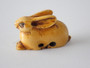 19th-century Japanese ivory rabbit netsuke with folded ears, rich honey patina and historical handling wear.