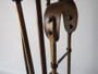 Victorian brass fireplace companion set with poker, tongs, shovel and brush on decorative stand circa 1880–1910.
