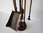 Victorian brass fireplace companion set with poker, tongs, shovel and brush on decorative stand circa 1880–1910.