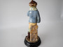 Antique Continental majolica Winter Boy ceramic figurine circa 1890–1910, wearing a blue coat and scarf and holding snowballs beside a stone wall.