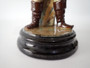 Antique Continental majolica Winter Boy ceramic figurine circa 1890–1910, wearing a blue coat and scarf and holding snowballs beside a stone wall.