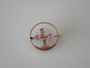 Antique 9ct gold circle brooch with three round faceted pink gemstones arranged as flowers, textured gold leaves and slender stems.