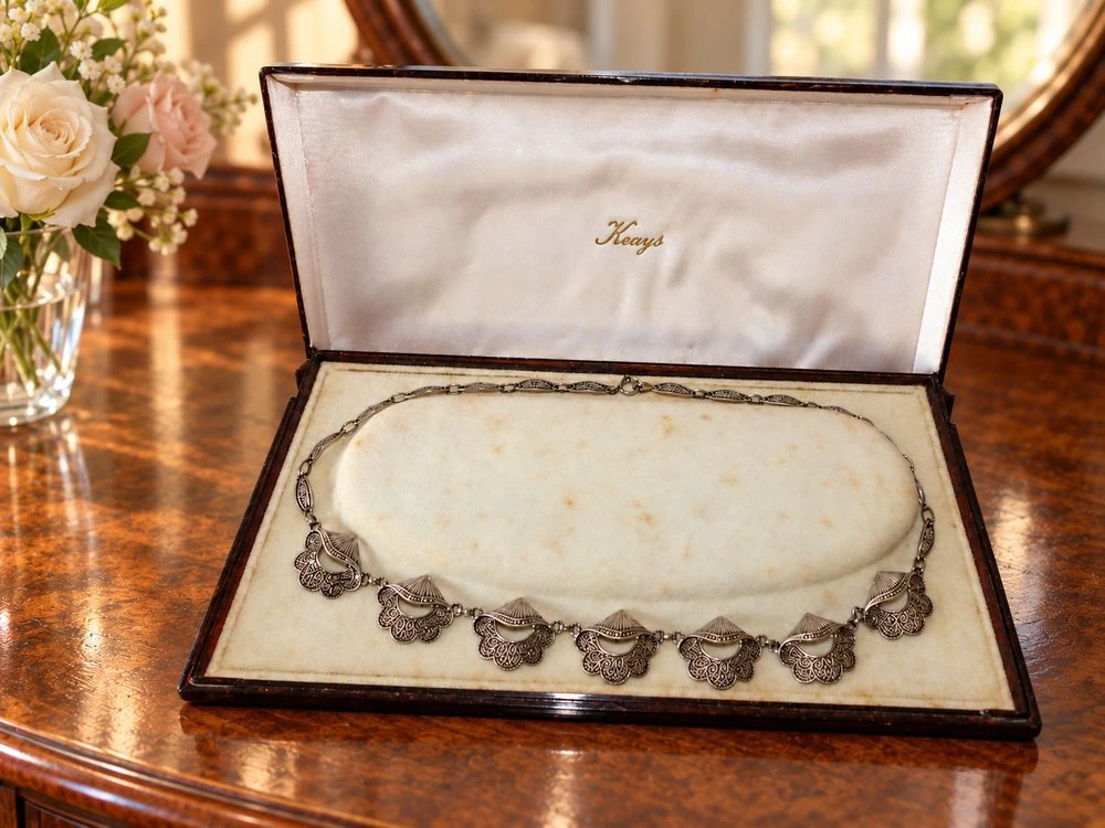 Theodor Fahrner Art Deco silver and marcasite necklace in its fitted box on a walnut dressing table beside flowers