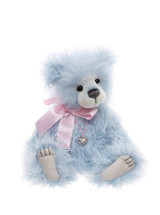 A light blue fluffy Charlie Bear sits upright against a white background, wearing a pink satin bow and silver heart locket necklace, with cream muzzle and paw pads.