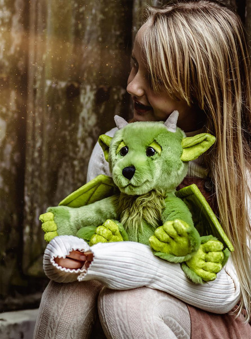 A green dragon-themed Charlie Bears plush toy sits upright against a white background, featuring bat-like wings, small horns, pointed ears, clawed feet, and expressive brown eyes.