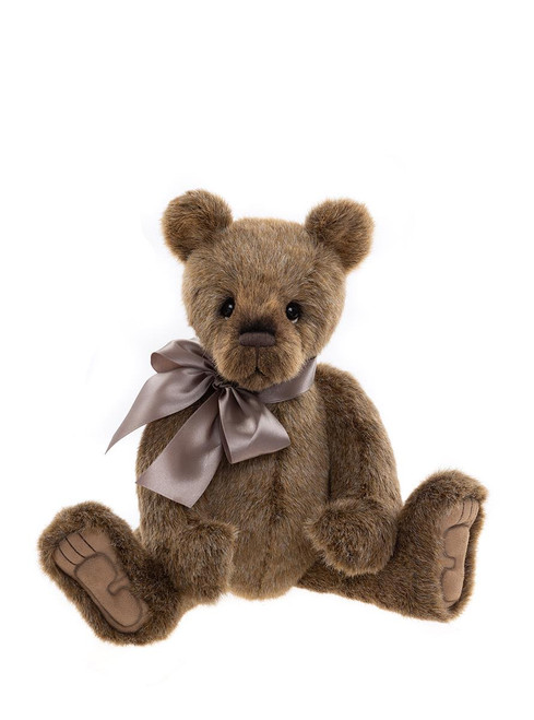 A brown plush Charlie Bears teddy bear sits upright against a white background, wearing a silver-grey satin ribbon bow tied around its neck.