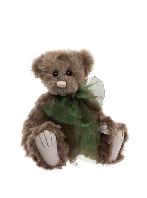 A small brown fluffy teddy bear sits upright against a white background, wearing a large green organza ribbon bow tied around its neck.