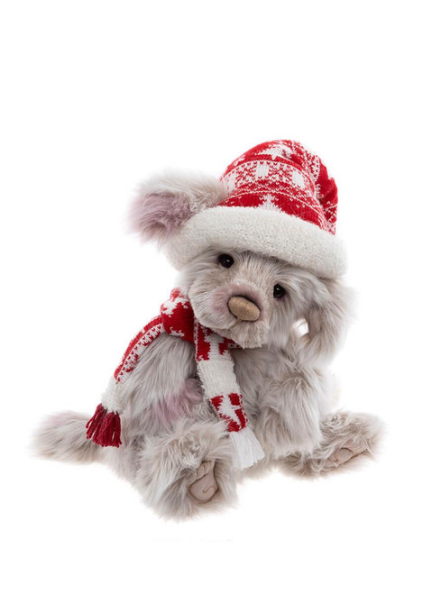 A grey Charlie Bears teddy bear sits wearing a red and white Nordic-patterned knit hat with white fluffy trim and a matching striped scarf with fringe tassels.
