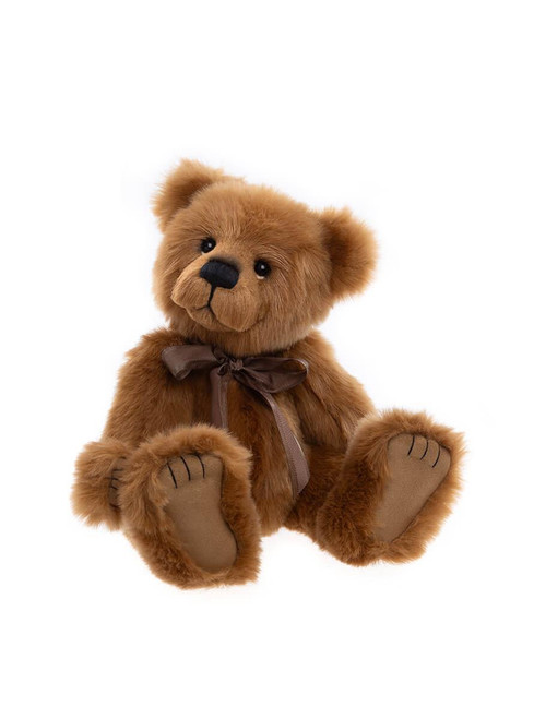 A classic golden-brown Charlie Bears teddy bear sits upright against a white background, wearing a satin brown bow around its neck, with suede-effect paw pads.